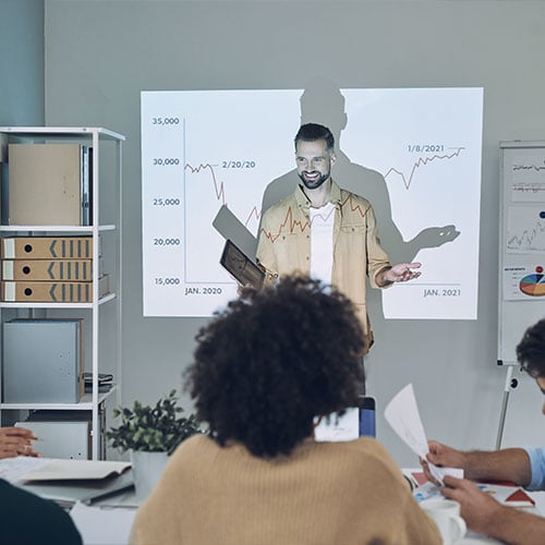 Man talking to team while standing in front of a whiteboard